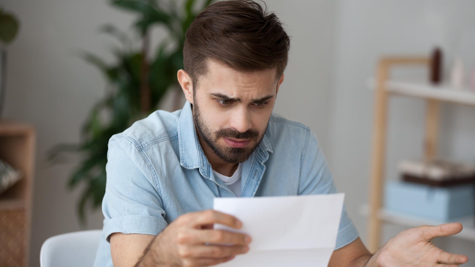 Homem lendo carta com expressão de dúvida após decisão sobre pedido de benefício