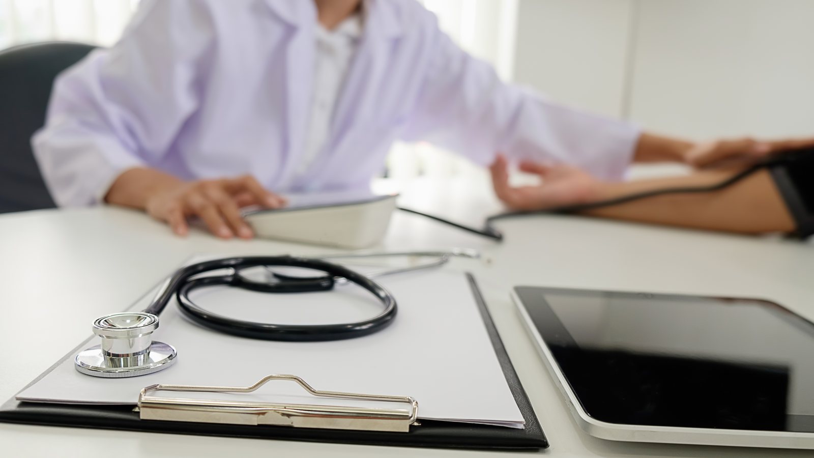 Estetoscópio sobre prancheta com documentos em consultório médico